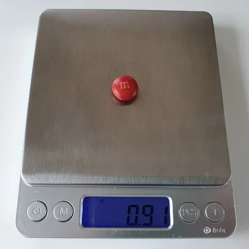image to show a chocolate m&m on a weighing scale
