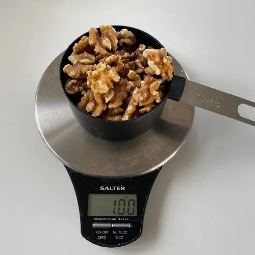 weight of a cup of half walnuts to show a cup weighs 100g