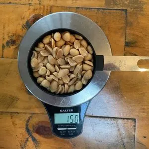 image to show the weight of one US cup of peanuts on a scale is 150g