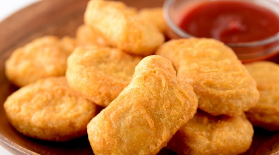 close up of nuggets on a plate with ketchup