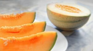 sliced cantaloupe melon and half a melon to show the kind of melon being weighed
