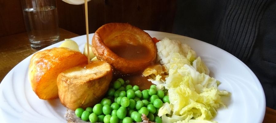 Person pouring gravy on a roast dinner