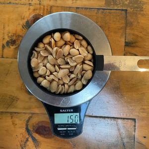 image to show the weight of one US cup of peanuts on a scale is 150g